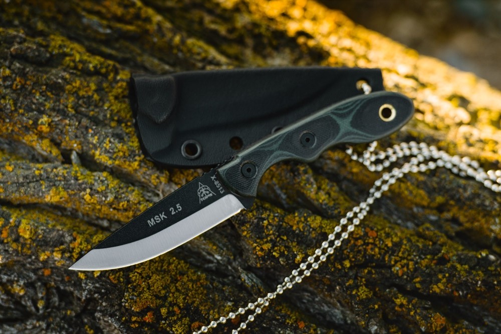 tops neck knife placed on rock